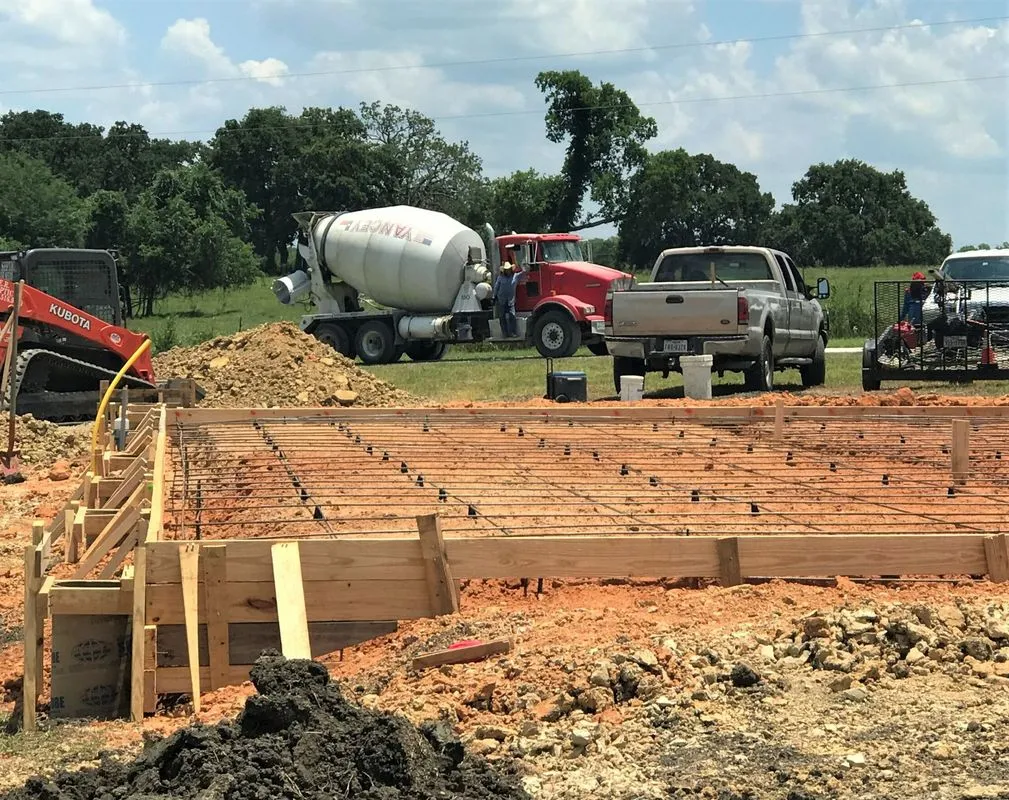 Formed and rebar-tied slab with a concrete mixer truck on site in Tomball, TX